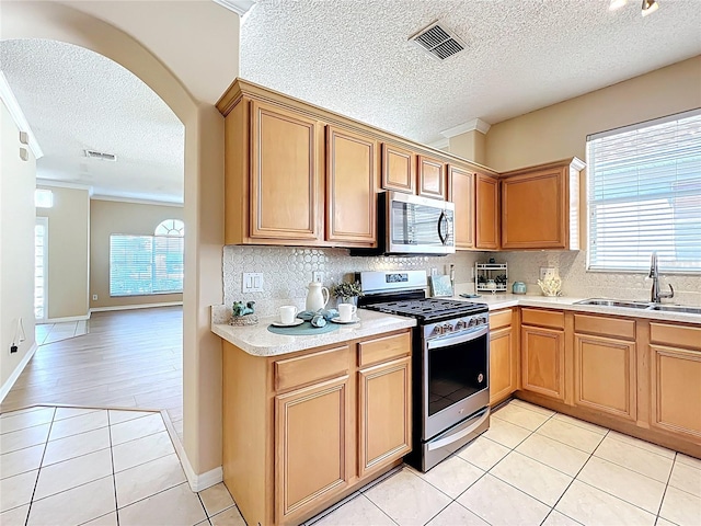 kitchen with light tile patterned flooring, visible vents, appliances with stainless steel finishes, and a sink