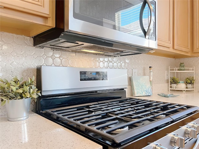 room details with stainless steel appliances, tasteful backsplash, cream cabinets, and light stone countertops