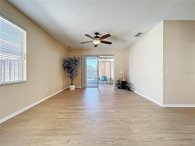 unfurnished room featuring a textured ceiling, light wood finished floors, and ceiling fan