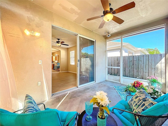 sunroom / solarium featuring a ceiling fan