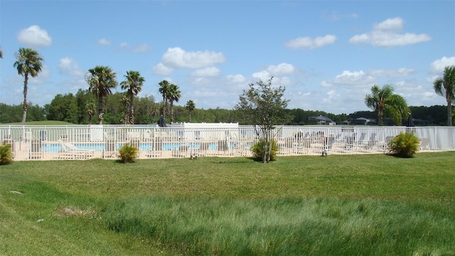 view of yard featuring a community pool and fence