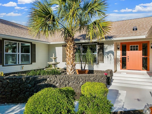 property entrance featuring roof with shingles