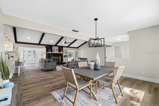 dining space with a notable chandelier, wood finished floors, baseboards, and vaulted ceiling with beams