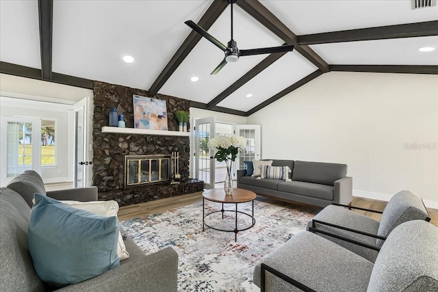 living area with a wealth of natural light, baseboards, wood finished floors, and vaulted ceiling with beams