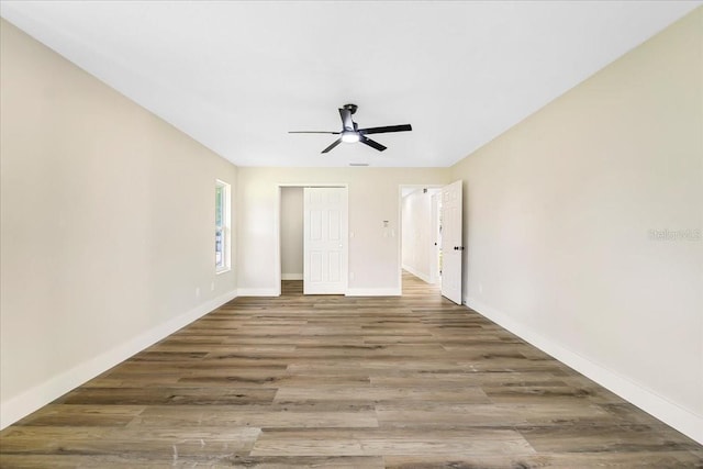 empty room featuring baseboards, a ceiling fan, and wood finished floors