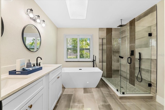 bathroom featuring a freestanding bath, double vanity, a stall shower, and a sink