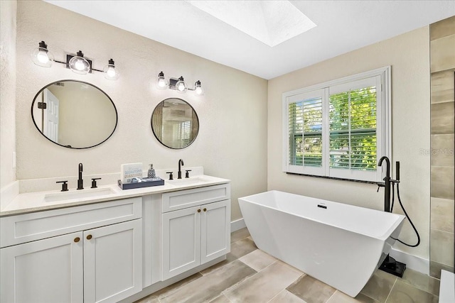 full bathroom with double vanity, a soaking tub, a skylight, and a sink