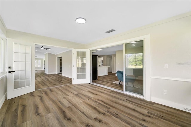 unfurnished room with visible vents, french doors, crown molding, and wood finished floors