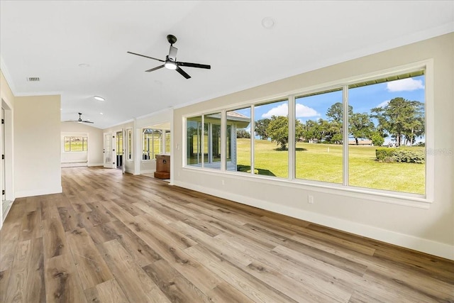 unfurnished living room with wood finished floors, baseboards, a ceiling fan, visible vents, and vaulted ceiling