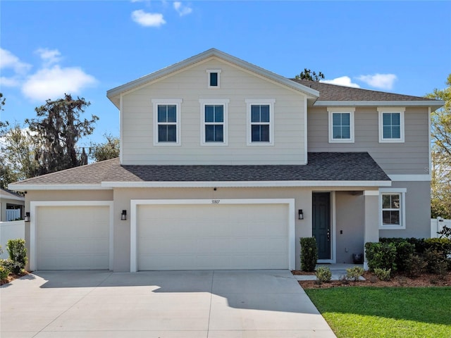 traditional home featuring stucco siding, concrete driveway, roof with shingles, and fence