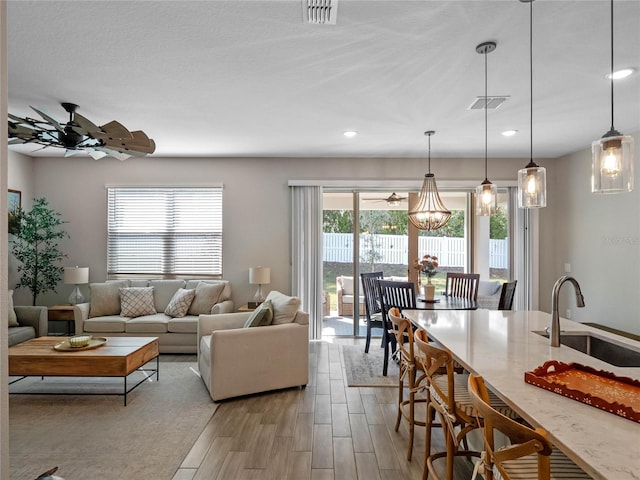 living area featuring recessed lighting, visible vents, ceiling fan, and light wood finished floors