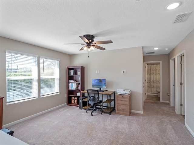 office with visible vents, baseboards, light colored carpet, and ceiling fan