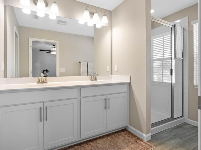 full bathroom with double vanity, visible vents, a stall shower, and a sink