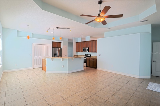 kitchen with visible vents, open floor plan, a breakfast bar, light countertops, and stainless steel appliances