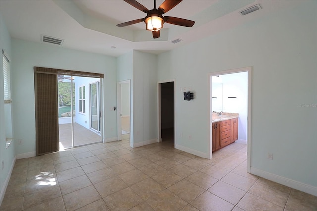 unfurnished bedroom featuring a tray ceiling, access to outside, visible vents, and a sink