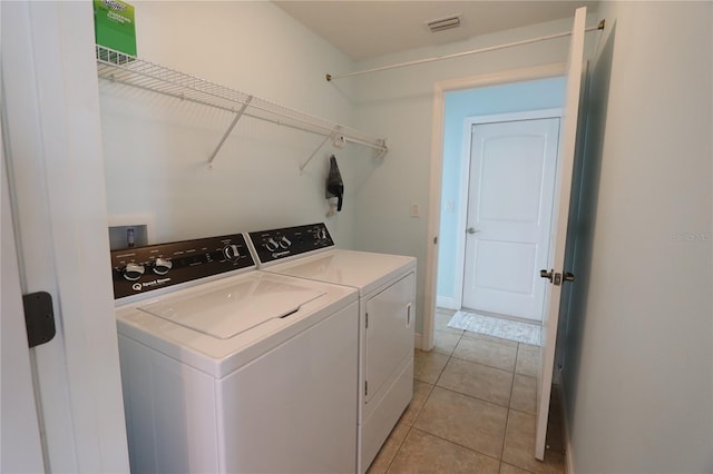 washroom featuring laundry area, light tile patterned floors, visible vents, and independent washer and dryer