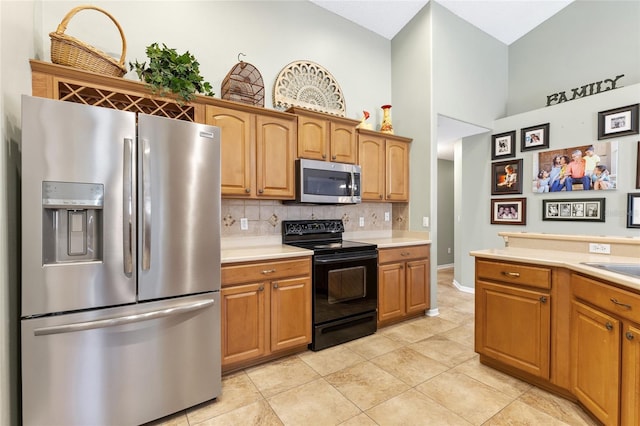 kitchen featuring backsplash, stainless steel appliances, light tile patterned flooring, brown cabinetry, and light countertops