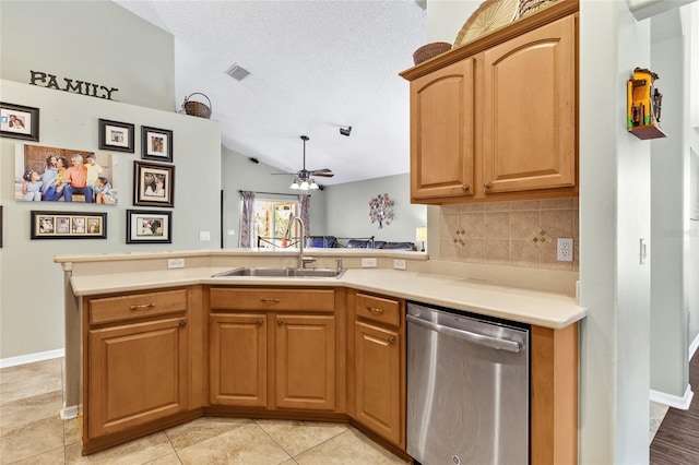 kitchen with ceiling fan, a sink, light countertops, stainless steel dishwasher, and backsplash