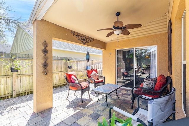 view of patio / terrace with ceiling fan and fence