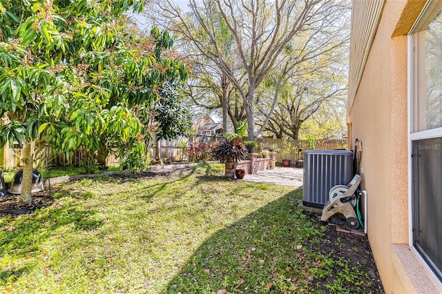 view of yard featuring central air condition unit, a fenced backyard, and a patio area