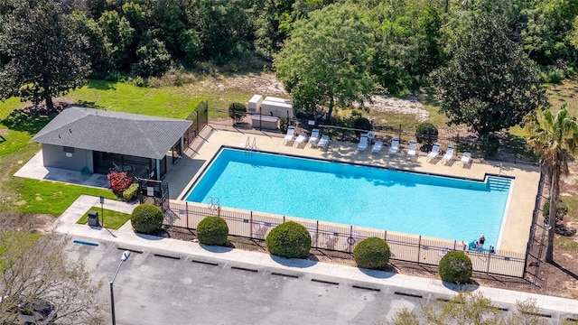 pool featuring a yard, a patio, and fence