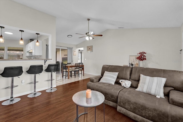 living room featuring visible vents, baseboards, vaulted ceiling, wood finished floors, and a ceiling fan