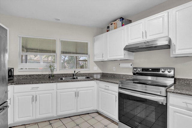 kitchen with dark stone countertops, a sink, appliances with stainless steel finishes, under cabinet range hood, and white cabinetry