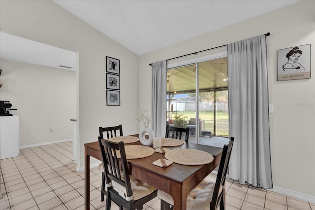 dining room featuring light tile patterned floors, baseboards, and lofted ceiling