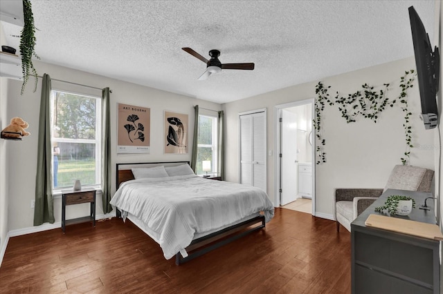 bedroom featuring ensuite bathroom, a textured ceiling, hardwood / wood-style floors, baseboards, and ceiling fan