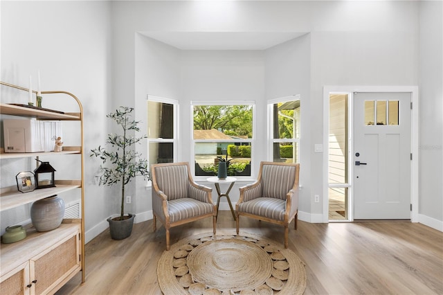 living area with baseboards and wood finished floors