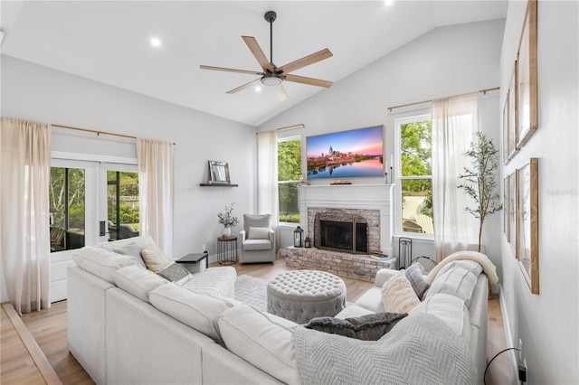 living room with a ceiling fan, french doors, a fireplace, and light wood finished floors