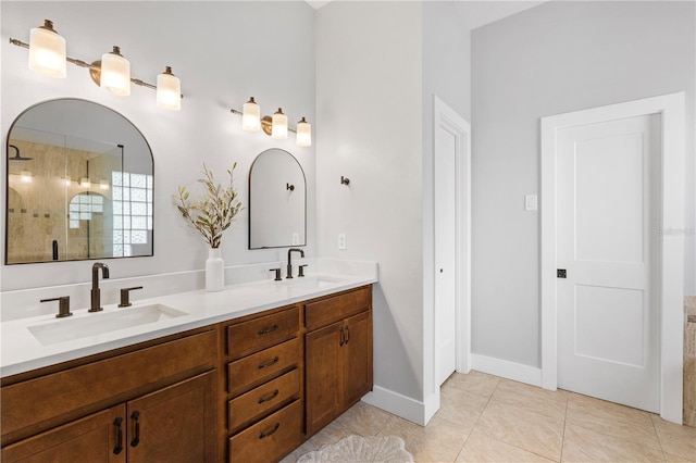 full bath with tile patterned flooring, double vanity, tiled shower, and a sink