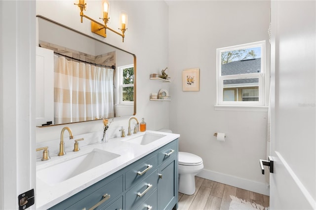 full bathroom featuring a notable chandelier, wood finished floors, toilet, and a sink