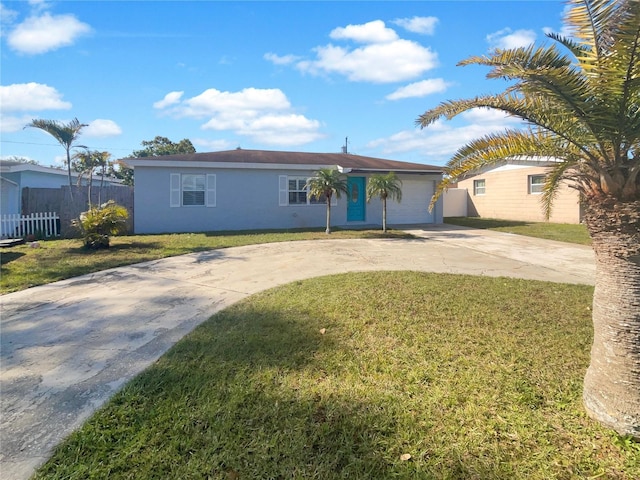 single story home featuring stucco siding, driveway, a front lawn, and fence