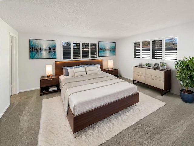 bedroom featuring baseboards, carpet floors, and a textured ceiling