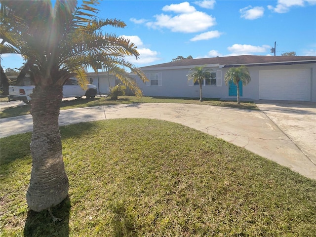 ranch-style house featuring curved driveway, an attached garage, a front yard, and stucco siding