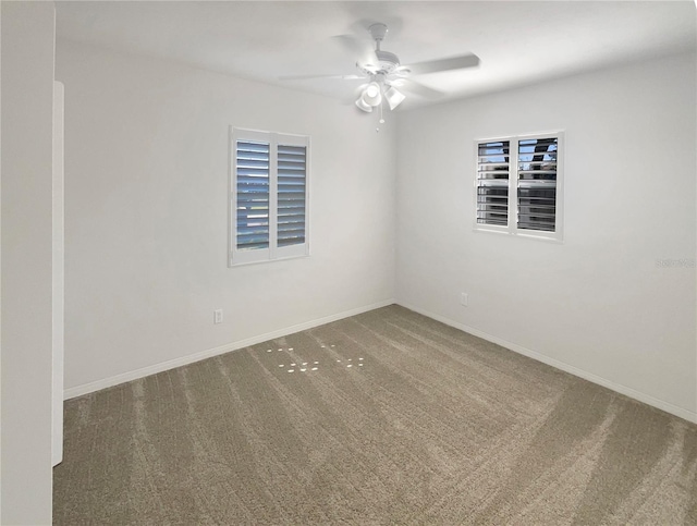 unfurnished room with carpet flooring, baseboards, and a ceiling fan