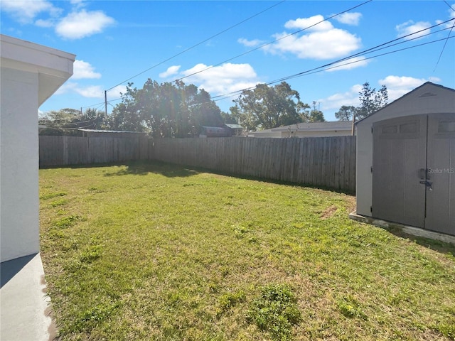 view of yard featuring an outbuilding, a fenced backyard, and a shed