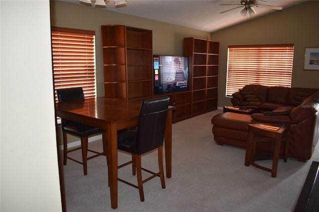 carpeted dining area with lofted ceiling and a ceiling fan