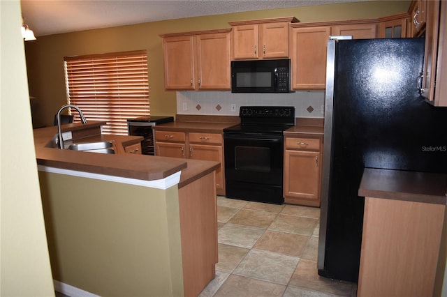 kitchen with black appliances, dark countertops, backsplash, and a sink