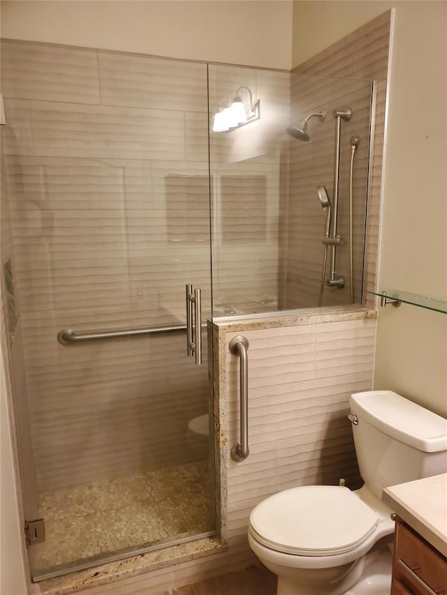 full bath with vanity, a shower stall, and toilet