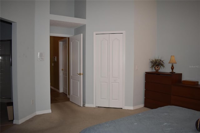 carpeted bedroom featuring a closet and baseboards