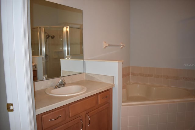 full bathroom with vanity, a bath, and a stall shower