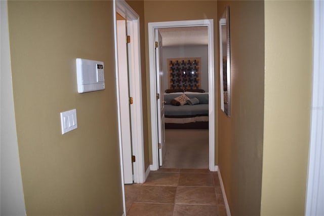 hallway with tile patterned flooring and baseboards