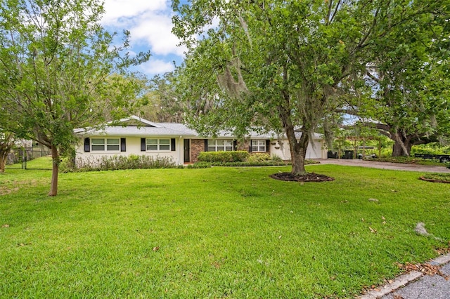 ranch-style house with concrete driveway, fence, a garage, and a front yard