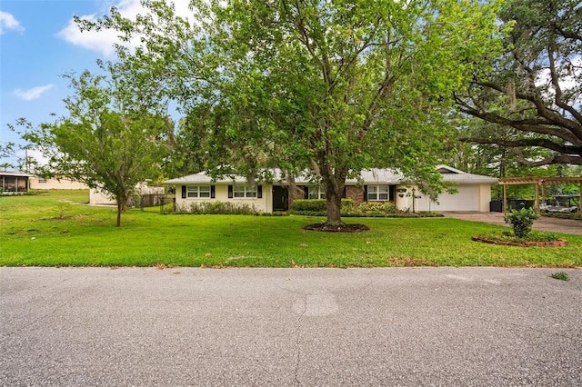 ranch-style house featuring stucco siding, an attached garage, driveway, and a front yard