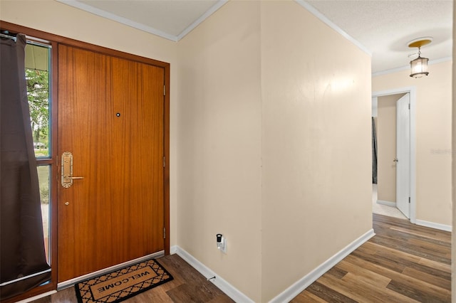 entryway with crown molding, baseboards, and wood finished floors