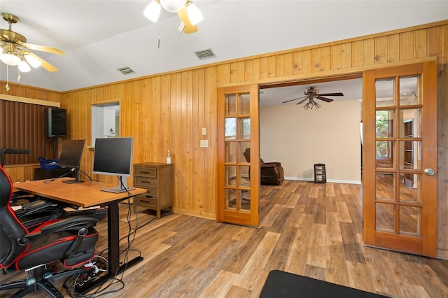 office area featuring wooden walls, a ceiling fan, visible vents, and french doors