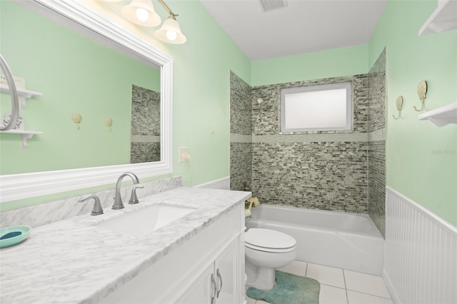 full bathroom featuring vanity, wainscoting, shower / bath combination, tile patterned floors, and toilet