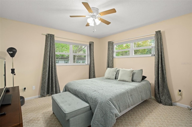 carpeted bedroom featuring baseboards, a textured ceiling, and ceiling fan